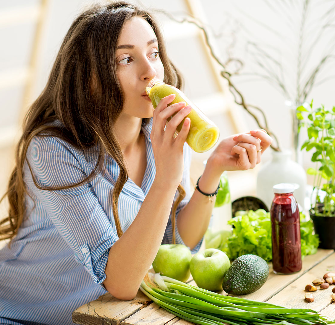 Woman drinking green juice.